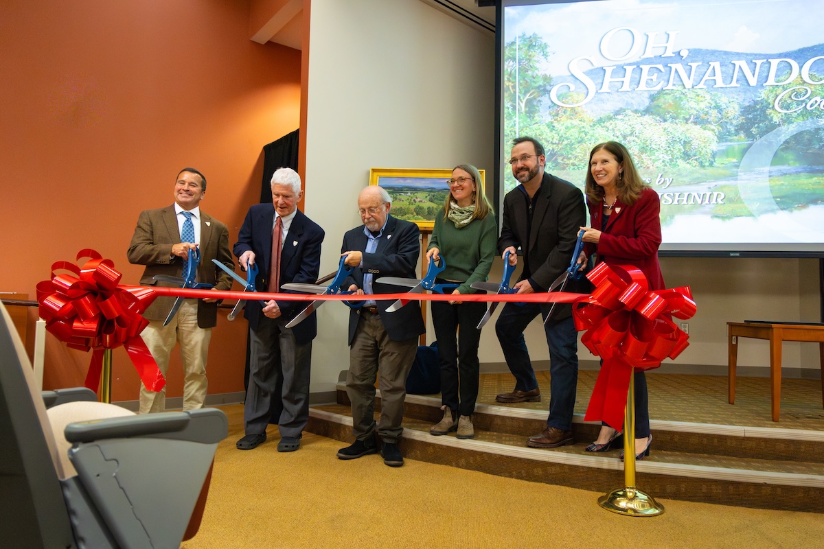 Individuals cut a ribbon celebrating the opening of the Andrei Kushnir Collection in Halpin-Harrison Hall.