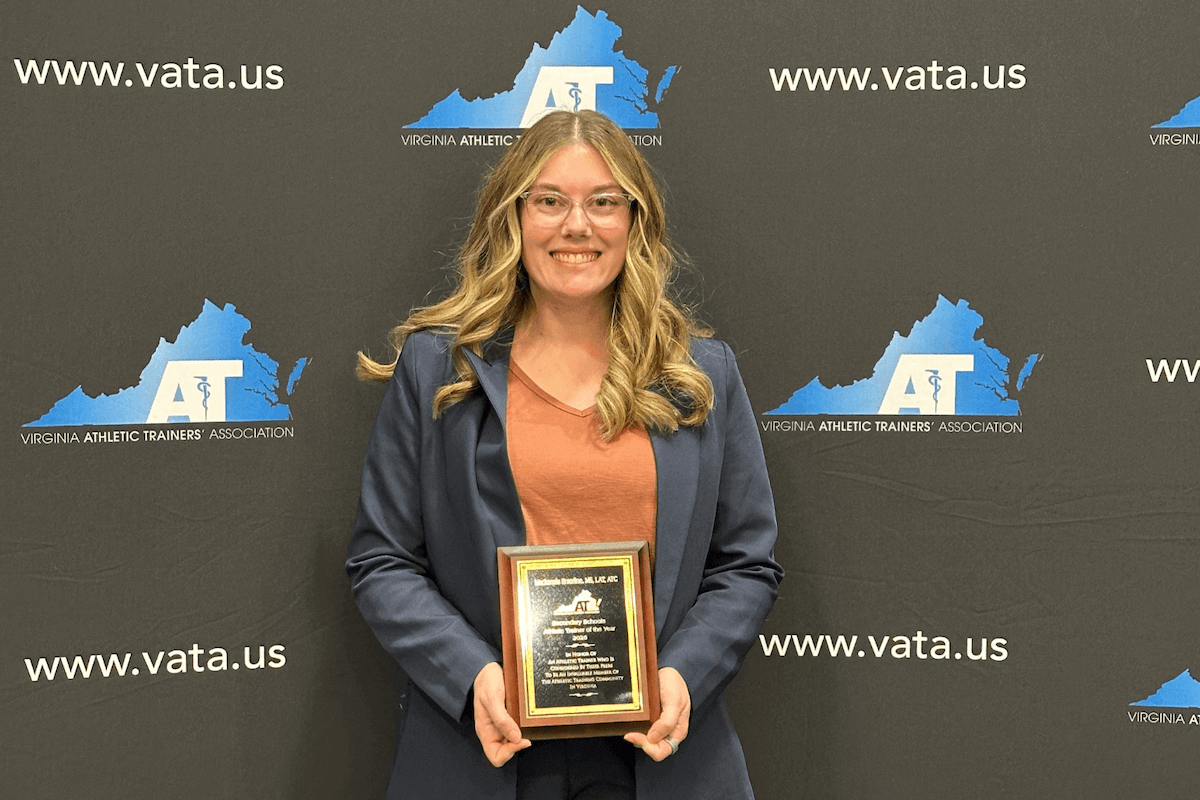 Mackenzie Enterline holds a plaque for the VATA Secondary Athletic Trainer of the Year award