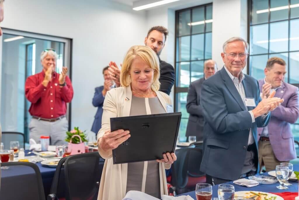 Kathleen Quarles admires a framed copy of a resolution of appreciation during the Board of Trustees meeting.