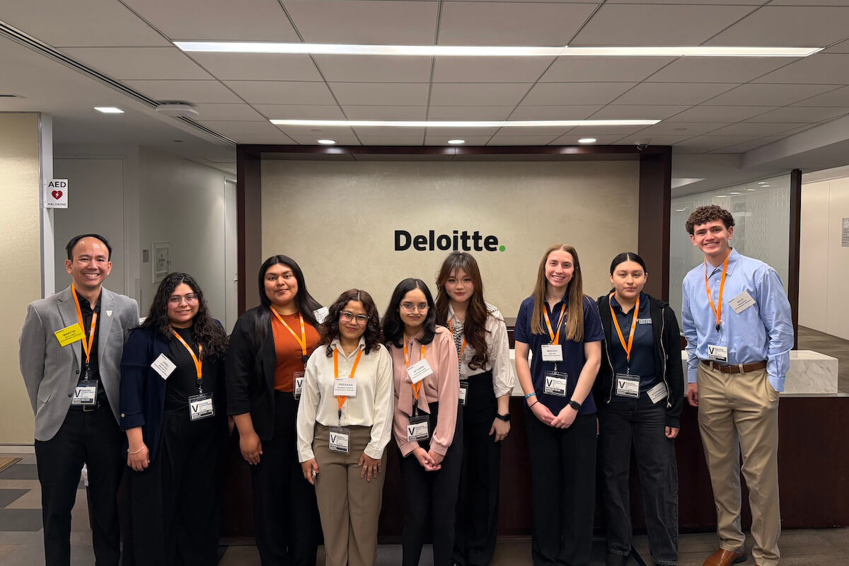 Accounting students and faculty pose for a photograph in one of Deloitte's offices.