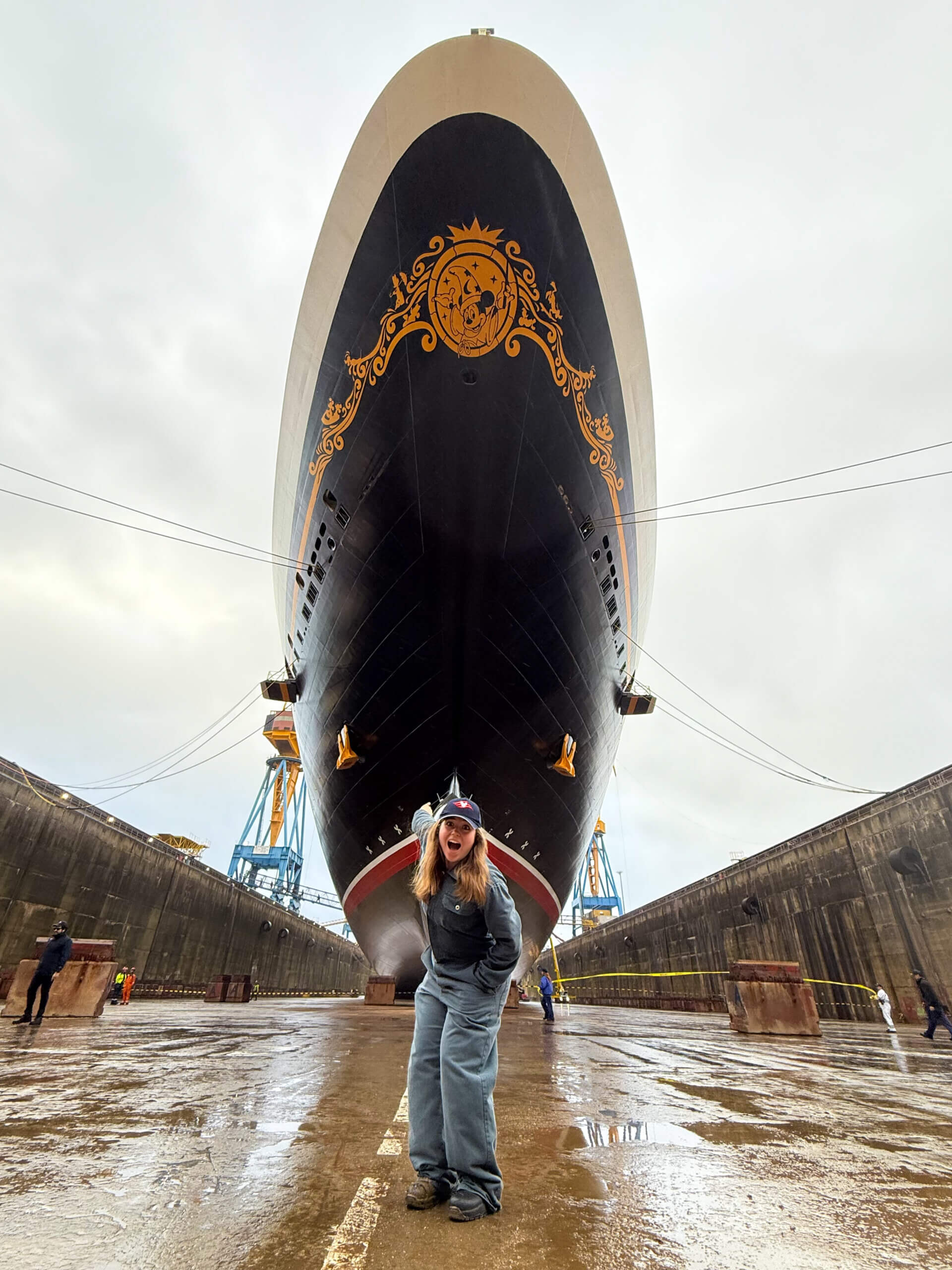 Alexa Guadagnoli '26 standing in front of the Disney Fantasy in dry dock