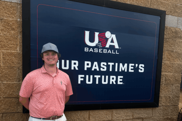 David Mann poses in front of a sign for USA Baseball.