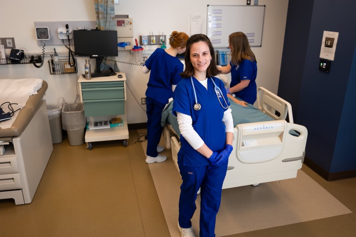 Shenandoah University nursing students, wearing blue scrubs in the university's simulation lab.