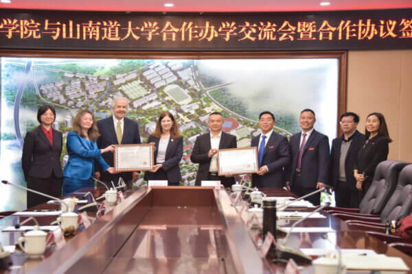 Officials from Shenandoah University and Yangtze Normal University pose for a group photograph while holding framed copies of a formal agreement between both universities.