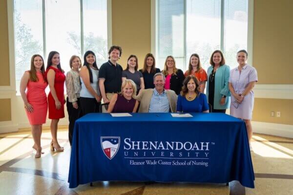 Kathleen and Billy Quarles, and Tracy Fitzsimmons seated a table surrounded by Shenandoah nursing faculty and students.