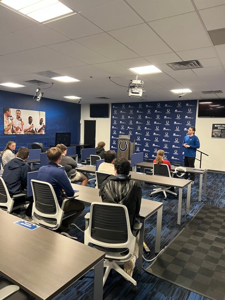 Students sit in a press conference room at the Indianapolis Colts' football facility.