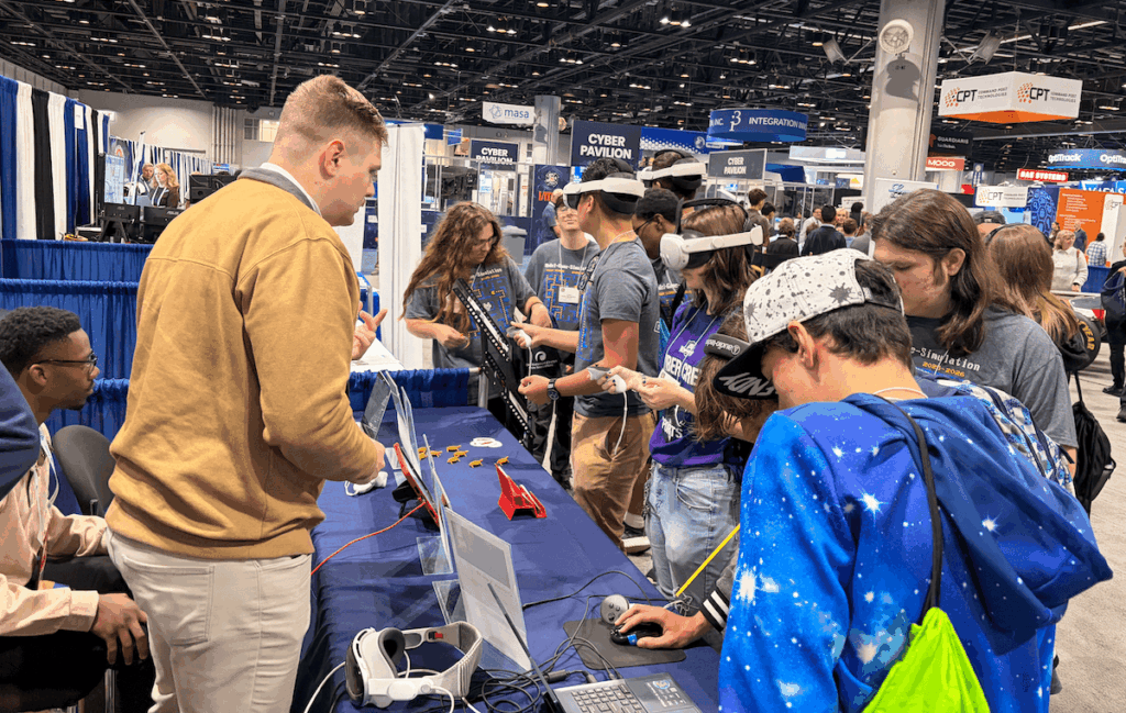 A group of children explore virtual reality projects at the SCiL booth.