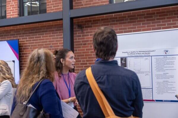 A student presents her research poster during the Shenandoah University Research Expo.