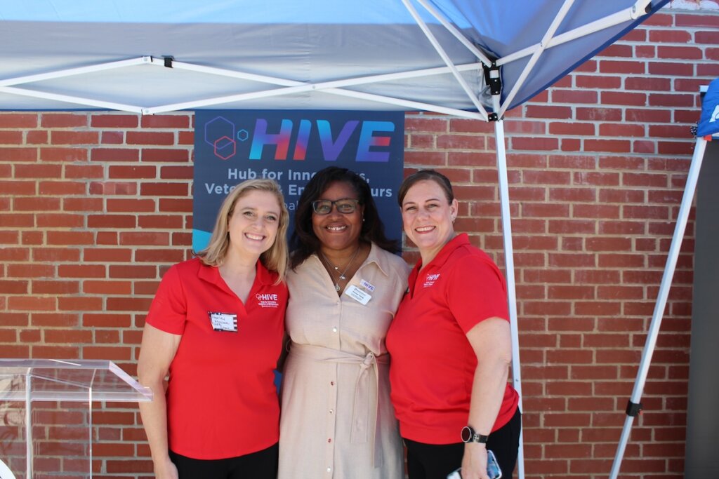 Three women pose for a photo outside the Hazel-Pruitt Armory.