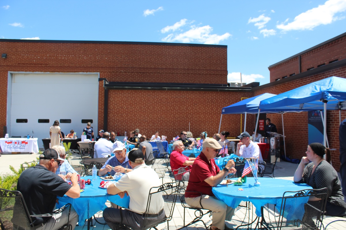 A group of people dine outside the Hazel-Pruitt Armory.