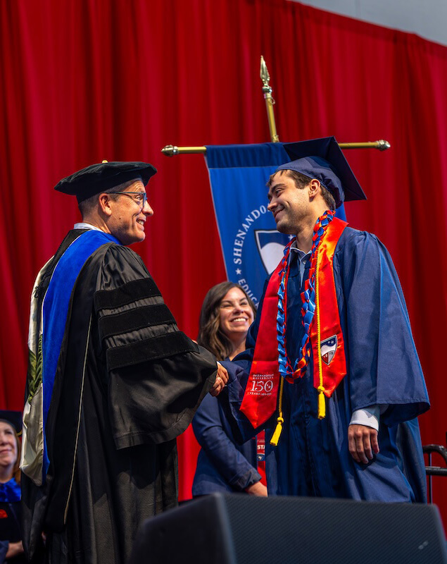 James Wilkins IV shakes hands with the dean of the School of Business.
