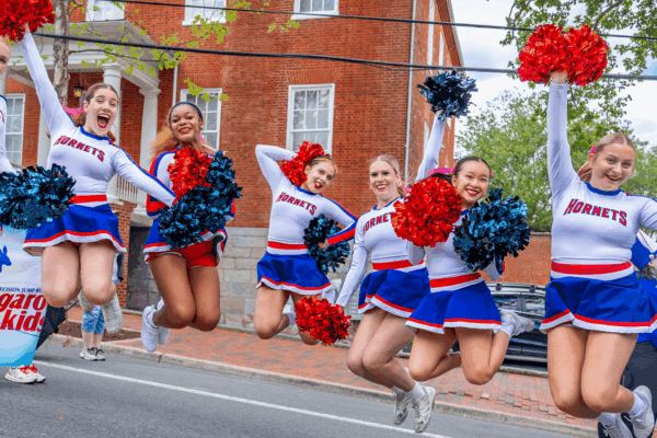 Cheerleaders jumping at a parade