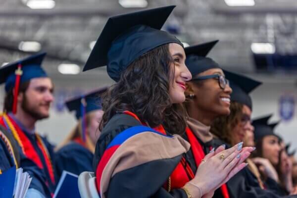 Maria Saikali '24, '26, prepares to graduate with her MBA at Shenandoah University's 2026 University Commencement in the James R. Wilkins Jr. Athletics & Events Center. She is wearing her cap and gown.