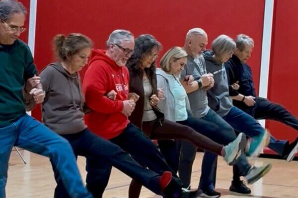 People with movement disorders participate in a dance kick line as part of a MoveU! Move to Music adaptive dance class at Shenandoah University.