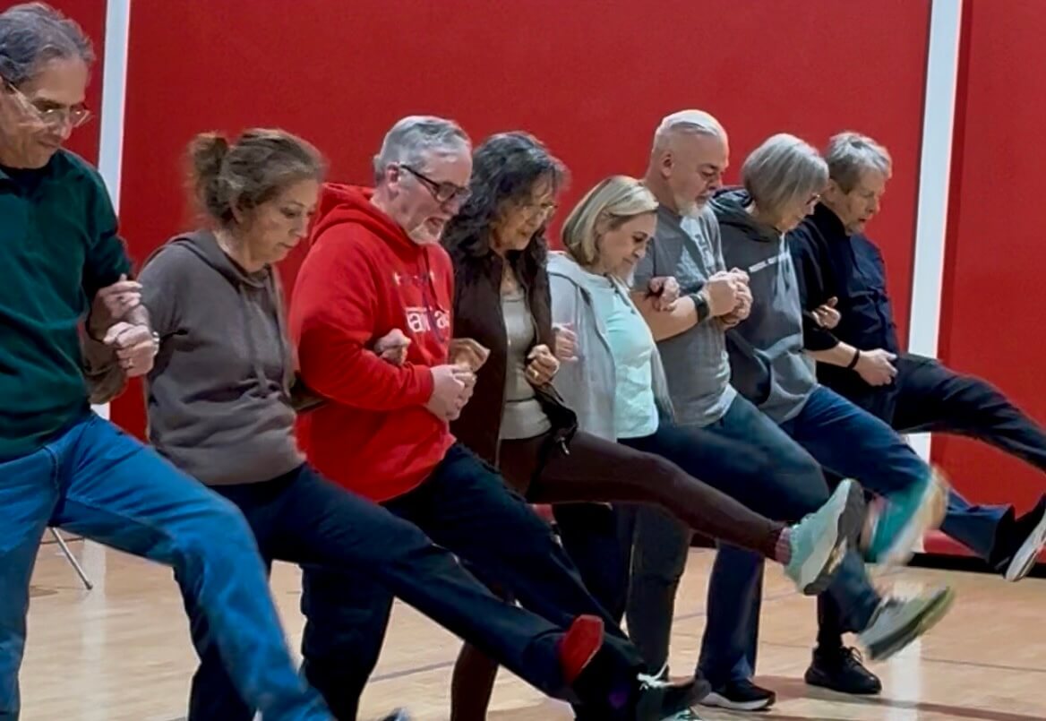 People with movement disorders participate in a dance kick line as part of a MoveU! Move to Music adaptive dance class at Shenandoah University.