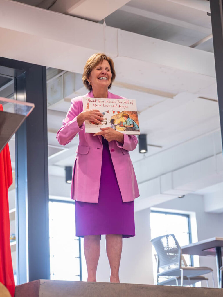 Karen Huff smiles while holding a memory book that was presented to her as a gift.