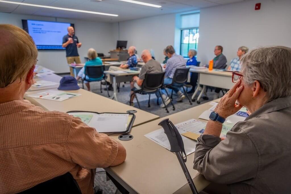 Older adults sit in a classroom.