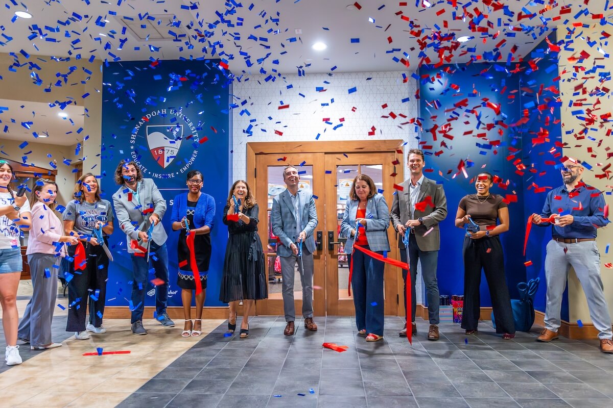 Officials from Shenandoah University and Slingshot cut a ceremonial ribbon amidst red and blue confetti.