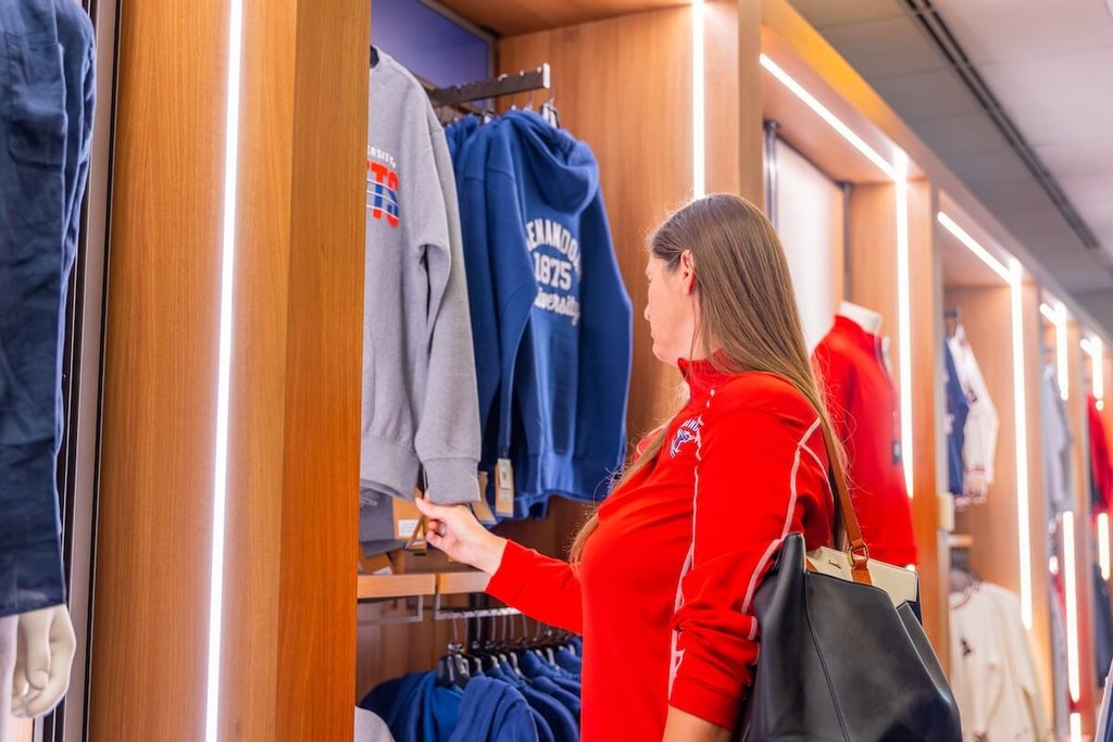 An individual looks at Shenandoah-branded sweatshirts.