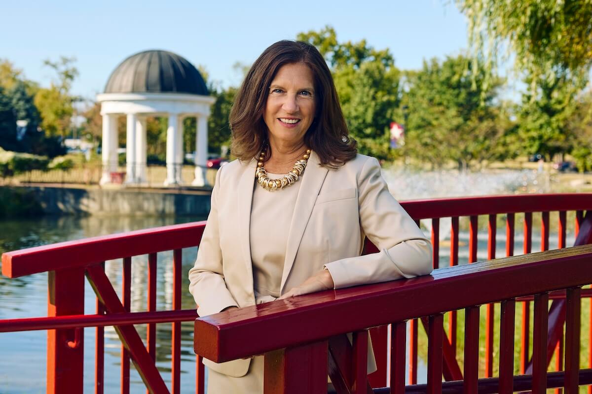 Tracy Fitzsimmons standing on a red bridge with a gazebo in the background.