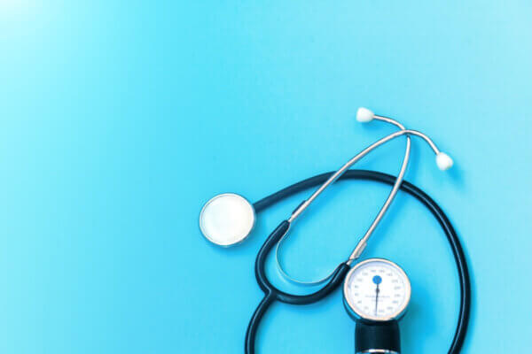 Stock image of a stethoscope on a sky blue background.
