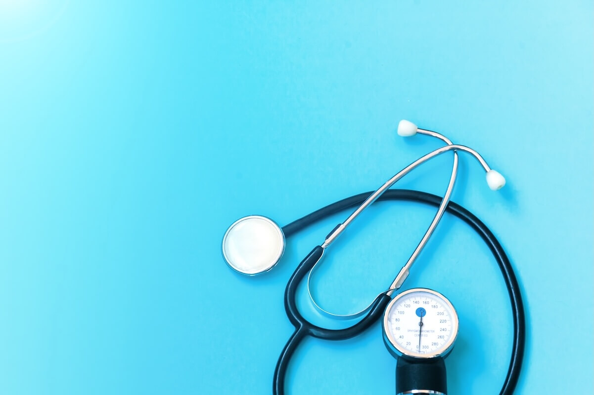 Stock image of a stethoscope on a sky blue background.