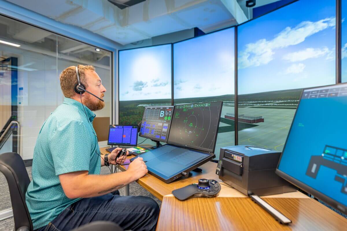 The director of aviation studies sits at a monitor in the air traffic control simulation lab.