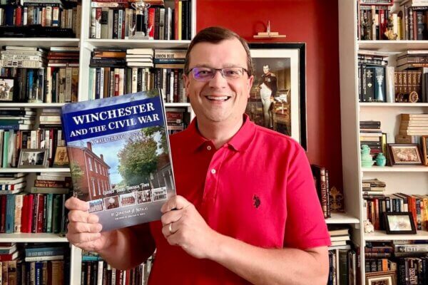 Shenandoah professor holds copy of his book