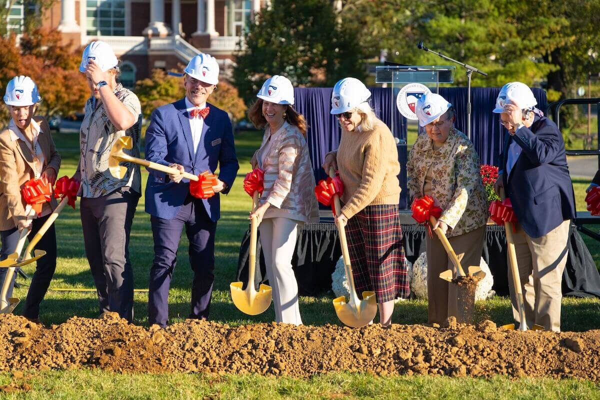 Shenandoah University administrators and supporters and city officials wear hardhats and use shovels during the ceremonial turning of the dirt for the Dove Center for the Arts groundbreaking.