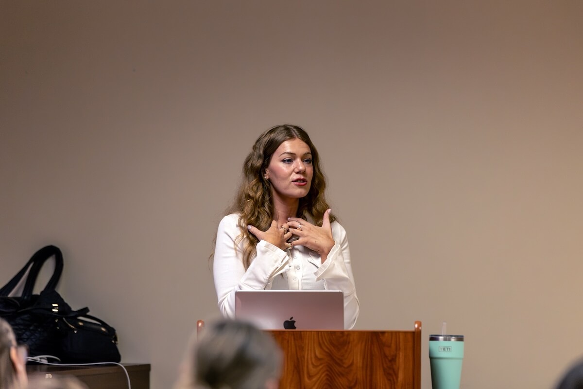 Singer-songwriter Enslow speaks at a podium.