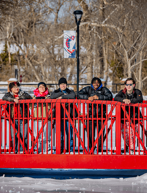 students on a red bridge in the snow