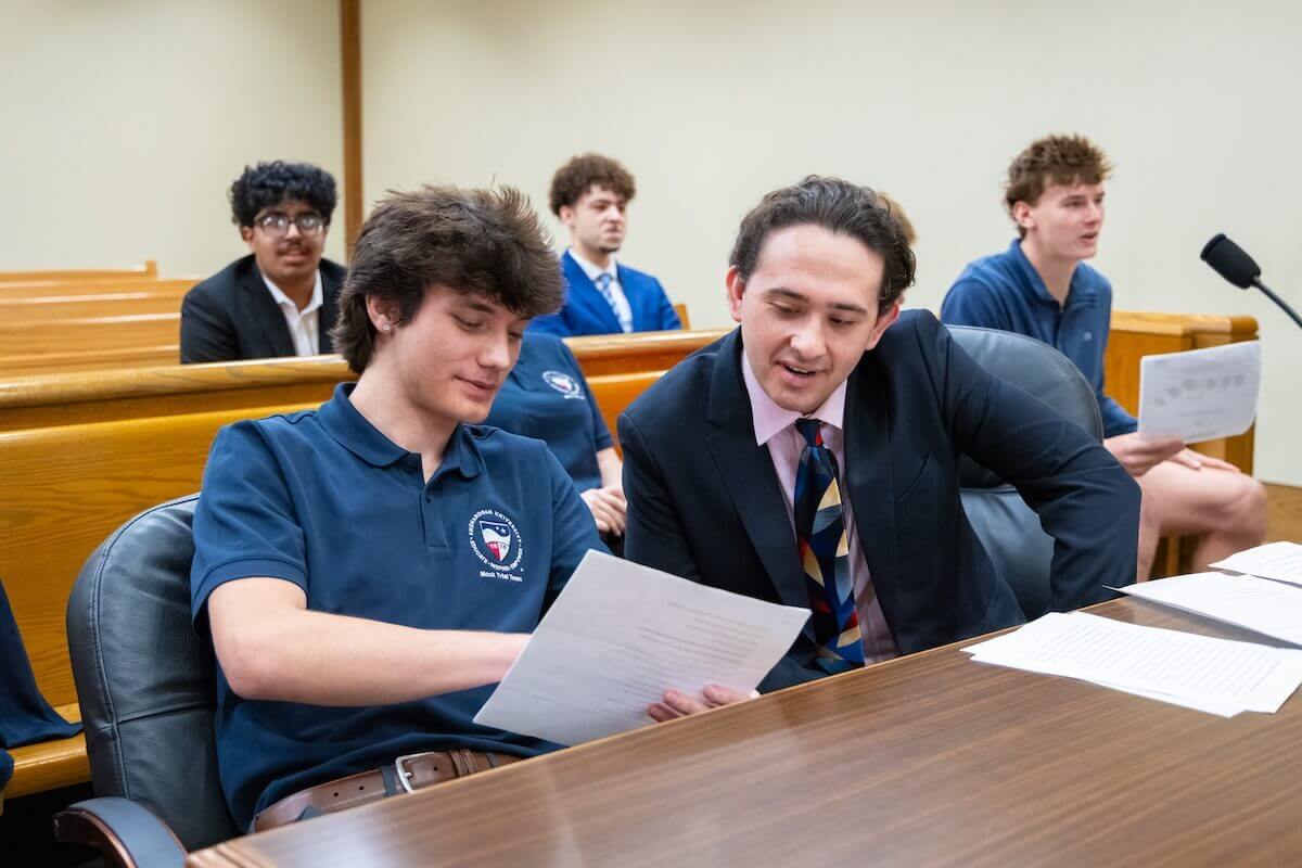 Two Shenandoah students play the roles of lawyer and client and examine a document during a mock trial scrimmage